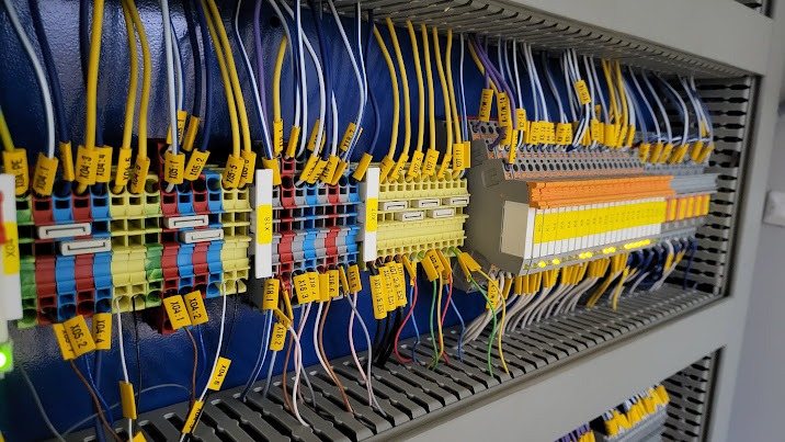 Okablowanie i listwy zaciskowe w szafie sterowniczej wykonanej przez Amperion.tech